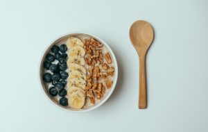 Breakfast Oatmeal with Fruit and Nuts on Top and a Glass of Orange Juice