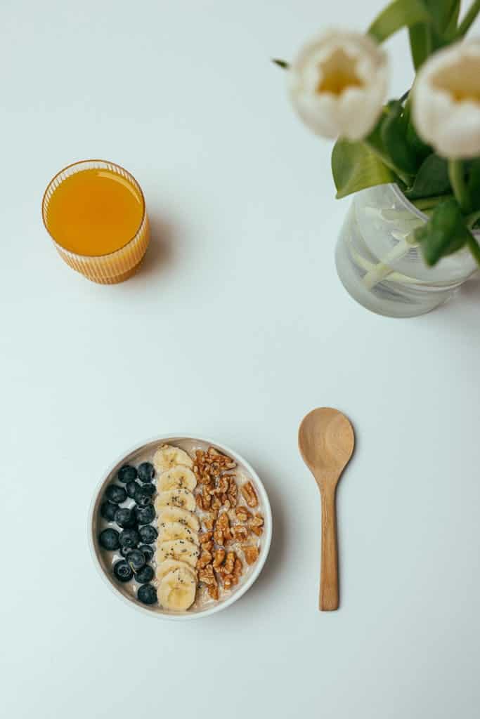Breakfast Oatmeal with Fruit and Nuts on Top and a Glass of Orange Juice