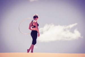 Frau mit Hula Hoop Reifen auf Sand